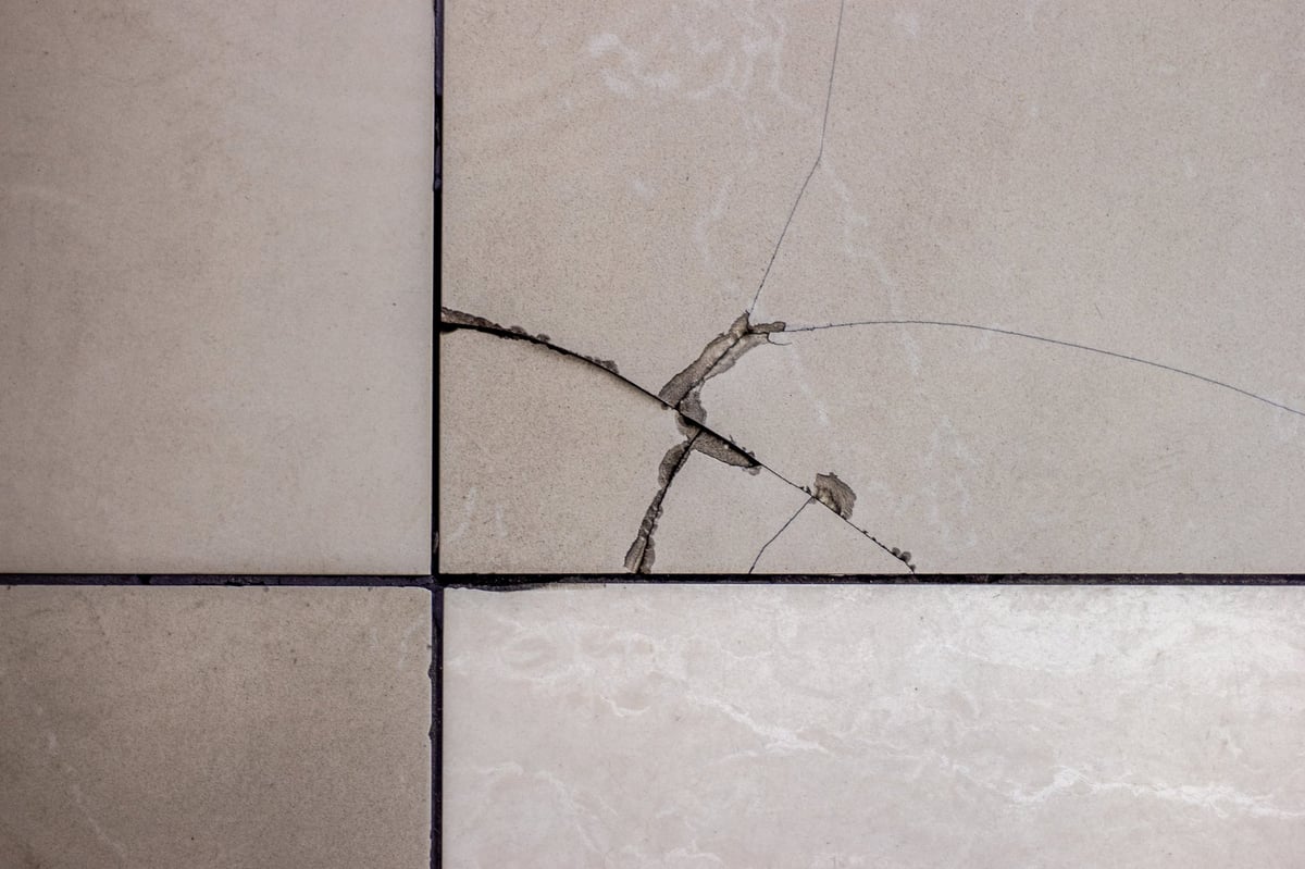 Cracked tile on the floor with broken tile surface